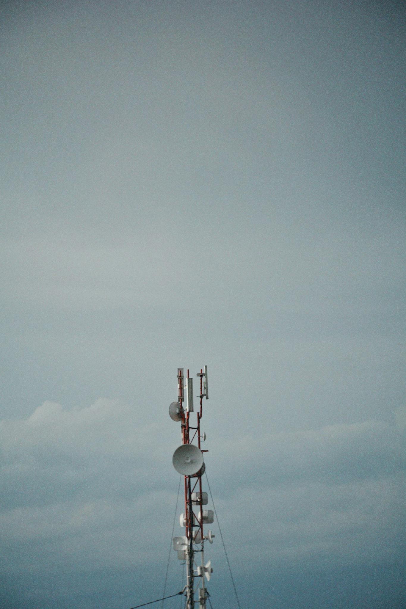 Vertical shot of a telecommunication tower standing against a cloudy sky in Talgar, Almaty Province, Kazakhstan.